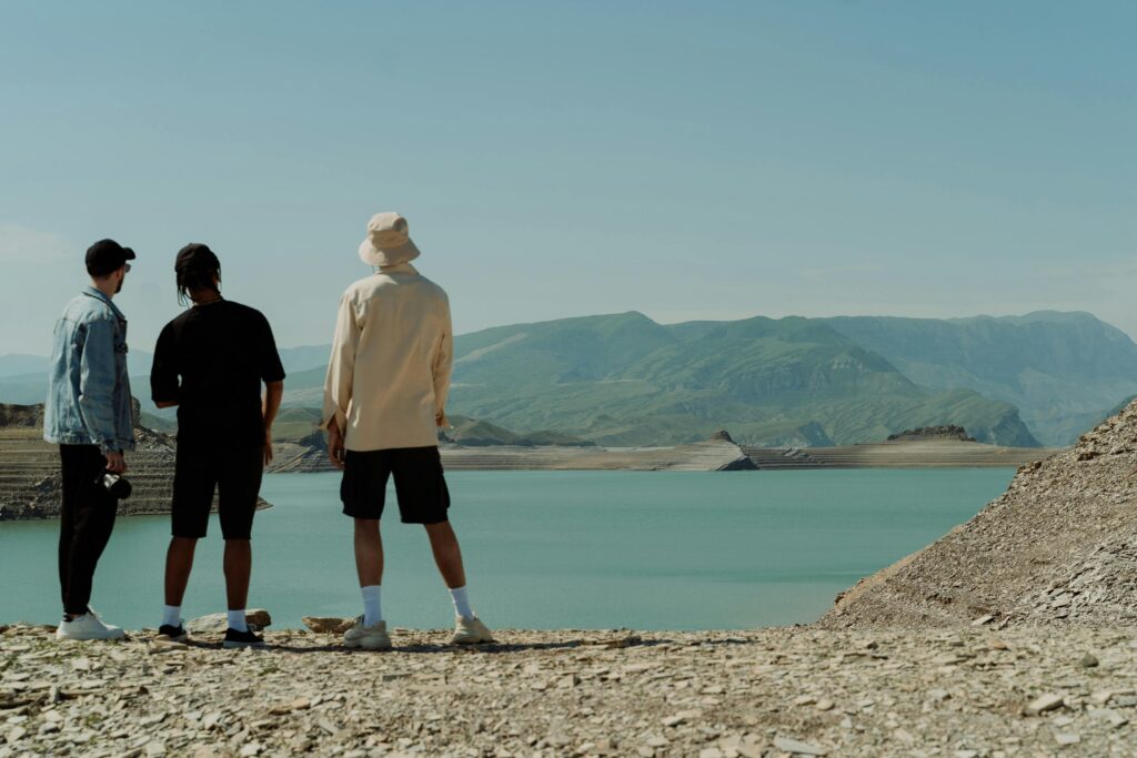 Three friends outside looking off in the distance toward mountains and connecting, as featured in an article about tips to improve mental health.